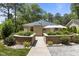 The home features a stone-lined raised flowerbed with manicured shrubbery flanking a walkway to the house at 2710 Broad St, Durham, NC 27704