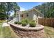 Inviting home featuring a red door, landscaping, and decorative stone accents at 2710 Broad St, Durham, NC 27704