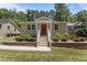 Charming single-story home with a red front door, white railings, brick foundation trim, and a well-manicured lawn at 2710 Broad St, Durham, NC 27704