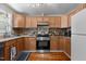 The kitchen features wooden cabinets, stainless steel appliances, and granite countertops for a modern look at 2710 Broad St, Durham, NC 27704