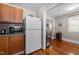 This kitchen features a stainless steel refrigerator, microwave, granite counters, and wood cabinets at 2710 Broad St, Durham, NC 27704