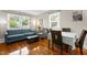 Bright living room with hardwood floors, a comfortable blue sofa, and dining area with large windows at 2710 Broad St, Durham, NC 27704