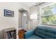 Cozy living room featuring hardwood floors, a blue sofa, a window with blinds, and a stylish floor lamp at 2710 Broad St, Durham, NC 27704