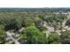 Aerial view showing a neighborhood with large trees and a distant city skyline at 2712 Broad St, Durham, NC 27704
