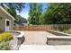 A brick patio is surrounded by a wooden fence and lush landscaping at 2712 Broad St, Durham, NC 27704