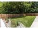 A lush green backyard featuring a wooden fence, rock borders and landscaped accents at 2712 Broad St, Durham, NC 27704