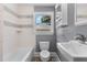 Bathroom with a white sink, toilet, bathtub, and a window with view to the outside at 2712 Broad St, Durham, NC 27704