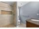 Bathroom with a stylish tile shower, a modern vanity with granite countertop and a painted brick wall at 2712 Broad St, Durham, NC 27704