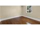Bedroom with hardwood floors and a window with a view of the house next door at 2712 Broad St, Durham, NC 27704
