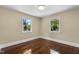 Bedroom with hardwood floors and two windows that provide a view of the trees at 2712 Broad St, Durham, NC 27704