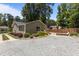 Charming home exterior featuring a gravel driveway, lush landscaping, and a wooden fence at 2712 Broad St, Durham, NC 27704