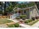 Charming home with a brick exterior, red door, white porch railing, and meticulously landscaped front yard at 2712 Broad St, Durham, NC 27704