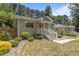 Charming home with a brick exterior, red door, white porch railing, and meticulously landscaped front yard at 2712 Broad St, Durham, NC 27704