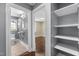 View of the hallway with tile floor leading to a bedroom with hardwood floor and built in shelving at 2712 Broad St, Durham, NC 27704