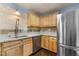 Bright kitchen with light wood cabinets, stainless steel refrigerator, granite countertops, and tiled backsplash at 2712 Broad St, Durham, NC 27704