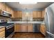 Charming kitchen featuring wooden cabinets, stainless steel appliances, granite counters, and a tiled backsplash at 2712 Broad St, Durham, NC 27704