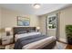 Nicely staged main bedroom with a bed and two bedside tables, a painting, and hardwood floors at 2712 Broad St, Durham, NC 27704