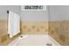 Relaxing bathtub with decorative tile surround and soft lighting, creating a spa-like atmosphere at 2721 Rustic Brick Rd, Raleigh, NC 27603