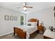 A bedroom features a ceiling fan, a window with view, artwork and wooden furniture at 2721 Rustic Brick Rd, Raleigh, NC 27603