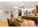 Elegant dining space with wood flooring, unique lighting, and seamless transition to the updated kitchen and comfortable bedroom at 2721 Rustic Brick Rd, Raleigh, NC 27603