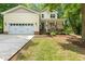 Inviting home exterior showcasing a two-car garage, front porch, and well-manicured lawn at 2721 Rustic Brick Rd, Raleigh, NC 27603