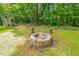 Charming backyard fire pit with stone surround, perfect for cozy outdoor gatherings and enjoying the natural setting at 2721 Rustic Brick Rd, Raleigh, NC 27603