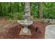 Multi-tiered fountain in a serene garden setting, adding charm and tranquility to the backyard landscape at 2721 Rustic Brick Rd, Raleigh, NC 27603