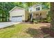 Inviting two-story yellow home with a charming porch, a well-maintained lawn, and attached garage at 2721 Rustic Brick Rd, Raleigh, NC 27603
