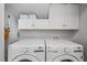Well-equipped laundry room with modern washer and dryer and overhead storage cabinets at 2721 Rustic Brick Rd, Raleigh, NC 27603
