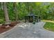 Expansive patio area featuring a fountain and gazebo with outdoor seating, surrounded by a tranquil wooded setting at 2721 Rustic Brick Rd, Raleigh, NC 27603