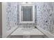 Stylish powder room with floral wallpaper, modern sink, and an ornate mirror at 2721 Rustic Brick Rd, Raleigh, NC 27603