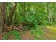 Neatly stacked woodpile surrounded by lush greenery, providing firewood for cozy evenings by the fire at 2721 Rustic Brick Rd, Raleigh, NC 27603