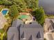 Aerial view showcases a home's roof and backyard oasis with a pool, landscaping, and lake access at 3004 Montville Valley Ct, Cary, NC 27519