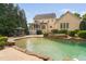 Relaxing backyard oasis featuring a gorgeous pool, waterfall feature, and a screened-in porch at 3004 Montville Valley Ct, Cary, NC 27519