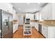 Spacious kitchen featuring white cabinets, stainless steel appliances, and hardwood floors at 3004 Montville Valley Ct, Cary, NC 27519