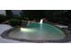 Backyard pool with a rock waterfall feature surrounded by lush trees and hardscape at 3004 Montville Valley Ct, Cary, NC 27519