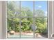 View of the beautiful outdoor pool, lush trees, and backyard, seen through a window at 3004 Montville Valley Ct, Cary, NC 27519