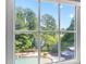 Backyard oasis seen from a window, showcasing a pool, lush landscaping, and private retreat at 3004 Montville Valley Ct, Cary, NC 27519