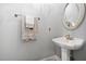 Elegant powder room featuring pedestal sink, decorative mirror, and neutral color scheme at 3004 Montville Valley Ct, Cary, NC 27519
