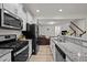 Well-equipped kitchen with stainless steel appliances, granite countertops, white cabinets, and an open view to the living area at 3015 Cypress Lagoon Ct, Durham, NC 27703