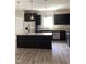 Modern kitchen with stainless steel appliances, dark cabinetry, granite countertops, and a center island at 305 Theys Mill, Fuquay Varina, NC 27526