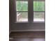 Bright interior view through two windows, revealing a wooden deck and lush green trees at 305 Theys Mill, Fuquay Varina, NC 27526