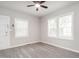 Bedroom with neutral paint, modern ceiling fan, and abundant natural light from the large windows at 308 Caswell St, Burlington, NC 27217