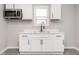Bright kitchen features white cabinetry, stainless microwave, black faucet, and a window for natural light at 308 Caswell St, Burlington, NC 27217