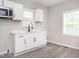 Bright kitchen featuring white cabinets, modern appliances and gray vinyl floors at 308 Caswell St, Burlington, NC 27217
