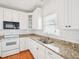 Well-lit kitchen with white cabinets, granite countertops, stainless steel appliances, and tile backsplash at 3303 Glen Currin Dr, Raleigh, NC 27612