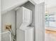 Bright laundry room featuring stacked washer/dryer and hardwood floors visible through the doorway at 3303 Glen Currin Dr, Raleigh, NC 27612