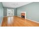 Bright and airy living room featuring a fireplace, hardwood floors, and a large window at 3303 Glen Currin Dr, Raleigh, NC 27612