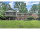 Large, well-maintained lawn and brick home with a second-story screened in porch at 3304 Redbud Ln, Raleigh, NC 27607