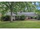 Charming brick home featuring a covered carport and lush landscaping at 3304 Redbud Ln, Raleigh, NC 27607